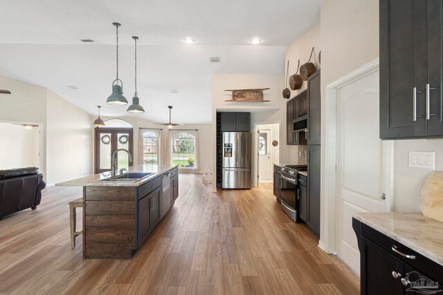 420 Palm Lake Dr, Pensacola, FL 32507 - kitchen featuring appliances with stainless steel finishes, a sink, light wood-style flooring, a center island with sink, and lofted ceiling
