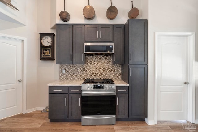 420 Palm Lake Dr, Pensacola, FL 32507 - kitchen featuring appliances with stainless steel finishes, tasteful backsplash, light wood-type flooring, and baseboards