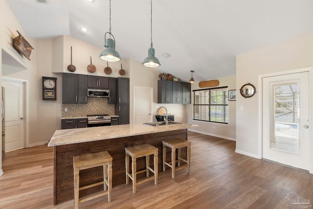 420 Palm Lake Dr, Pensacola, FL 32507 - kitchen featuring a sink, appliances with stainless steel finishes, a breakfast bar area, baseboards, and light wood-style flooring