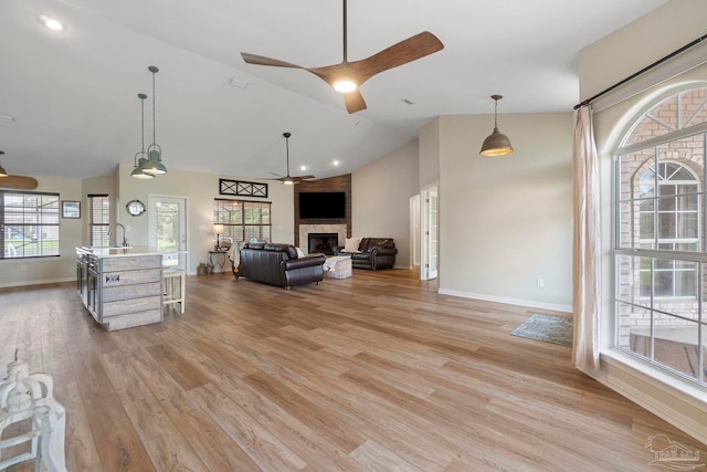 420 Palm Lake Dr, Pensacola, FL 32507 - living area featuring baseboards, ceiling fan, a fireplace, light wood-style floors, and high vaulted ceiling