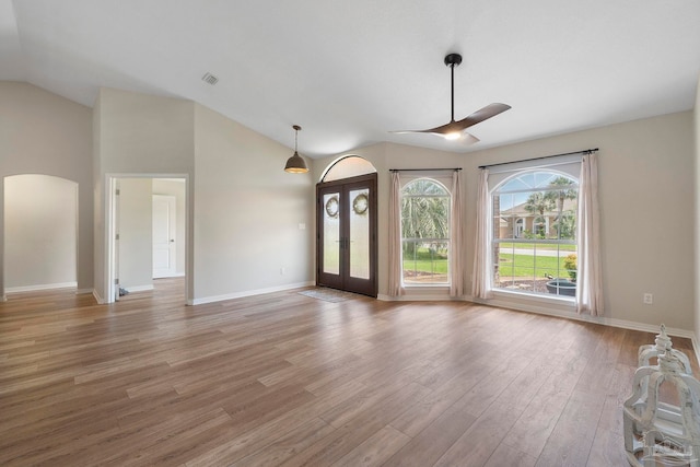 420 Palm Lake Dr, Pensacola, FL 32507 - unfurnished living room featuring lofted ceiling, a ceiling fan, light wood-type flooring, arched walkways, and baseboards