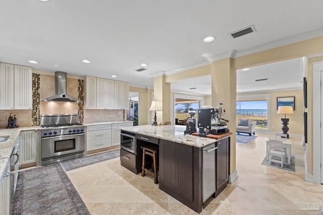 kitchen featuring tasteful backsplash, visible vents, appliances with stainless steel finishes, ornamental molding, and wall chimney exhaust hood