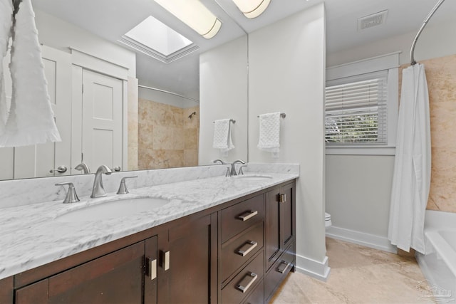 bathroom featuring toilet, a skylight, visible vents, and a sink