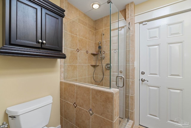 bathroom with a shower stall and toilet