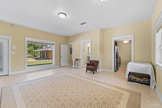 interior space featuring light tile patterned floors, visible vents, and baseboards