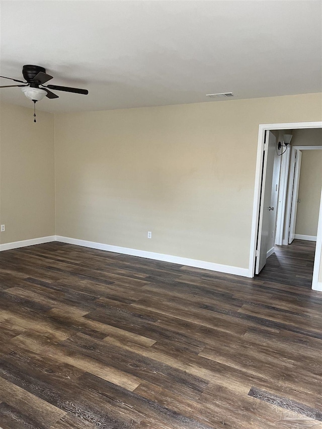 empty room with dark hardwood / wood-style floors and ceiling fan