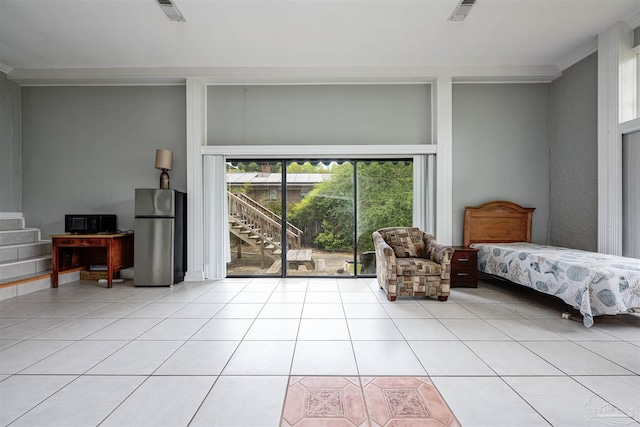 bedroom with stainless steel fridge and light tile patterned floors