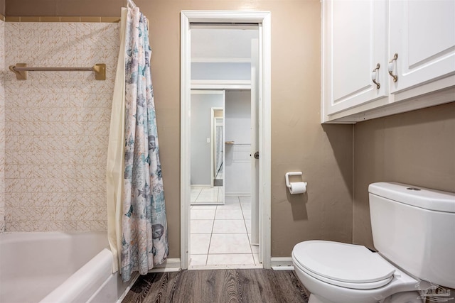 bathroom featuring toilet, shower / bathtub combination with curtain, and hardwood / wood-style floors