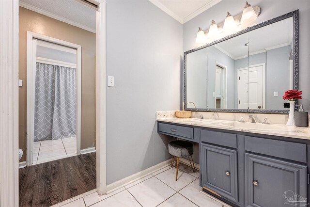 bathroom with toilet, vanity, crown molding, and hardwood / wood-style floors