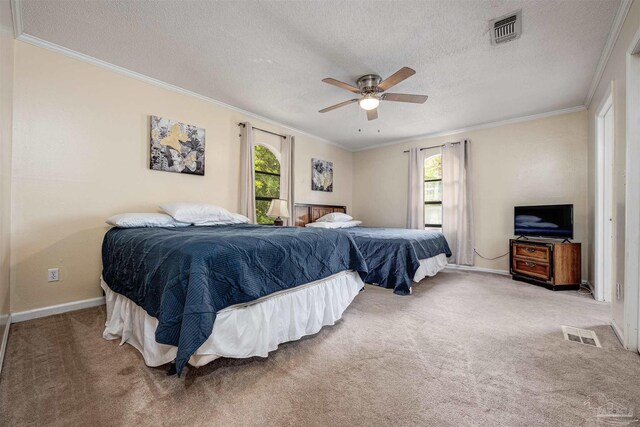 carpeted bedroom featuring ornamental molding, multiple windows, a textured ceiling, and ceiling fan