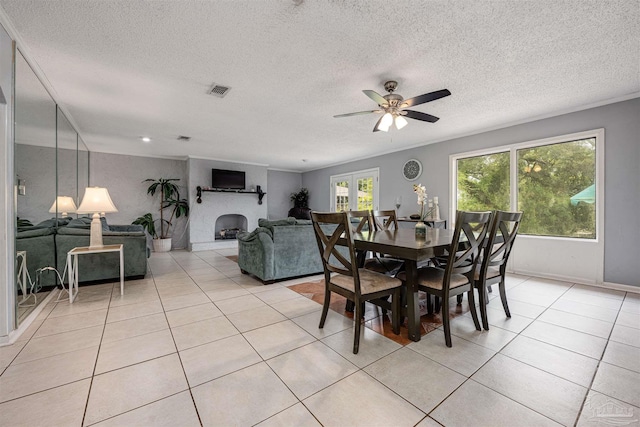 tiled dining room featuring a textured ceiling, ceiling fan, and french doors