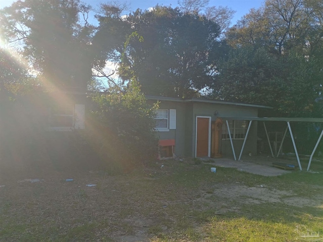 rear view of property featuring stucco siding