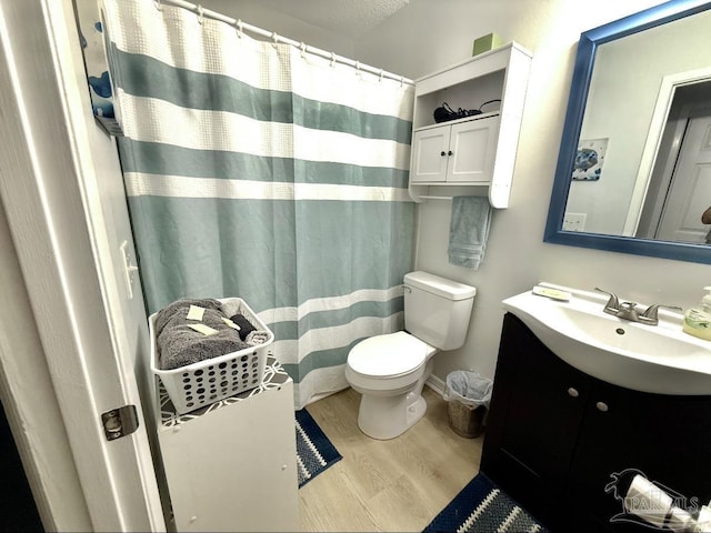 bathroom featuring a shower with curtain, vanity, toilet, and wood finished floors