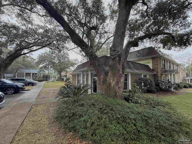 view of side of property featuring a yard and brick siding