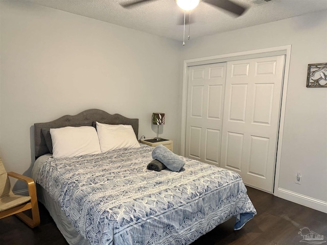 bedroom with dark wood finished floors, a closet, ceiling fan, a textured ceiling, and baseboards