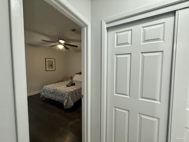 bedroom featuring baseboards, visible vents, and wood finished floors