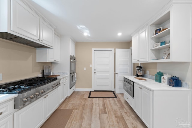 kitchen featuring appliances with stainless steel finishes, light hardwood / wood-style flooring, and white cabinetry