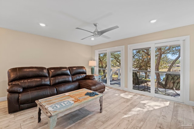 living room featuring ceiling fan and light hardwood / wood-style flooring