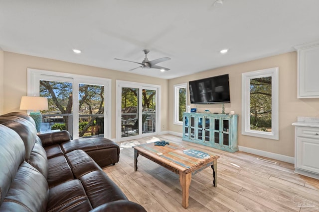 living room with light wood-type flooring and ceiling fan