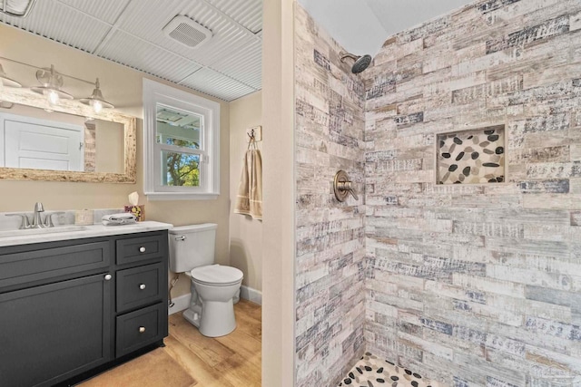 bathroom with toilet, vanity, hardwood / wood-style flooring, and walk in shower