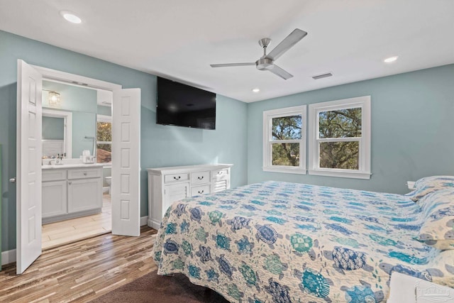 bedroom featuring ceiling fan, light hardwood / wood-style floors, and connected bathroom