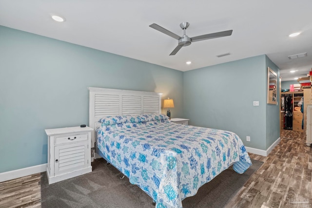 bedroom with a walk in closet, a closet, and ceiling fan