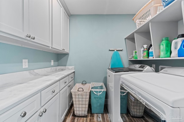 laundry room featuring washer and dryer, dark hardwood / wood-style flooring, and cabinets