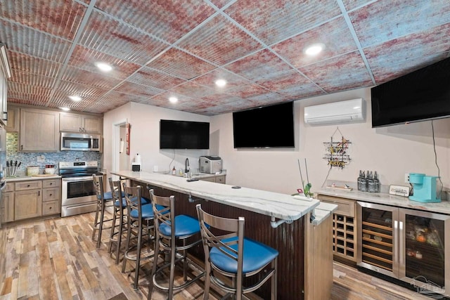 bar featuring a wall unit AC, wine cooler, light hardwood / wood-style floors, stainless steel appliances, and backsplash