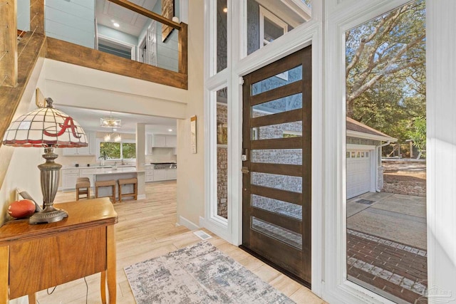 entrance foyer with an inviting chandelier and light hardwood / wood-style floors