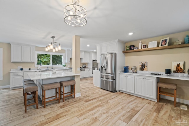 kitchen with a kitchen bar, white cabinetry, stainless steel refrigerator with ice dispenser, and hanging light fixtures