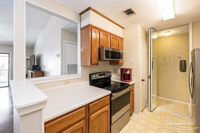 2299 Scenic Hwy Unit T7, Pensacola, FL 32503 - kitchen with appliances with stainless steel finishes, brown cabinets, a textured ceiling, and light countertops