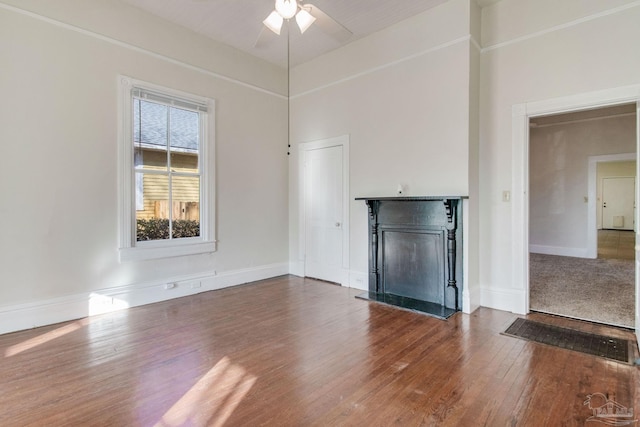 unfurnished living room featuring ceiling fan and dark hardwood / wood-style floors