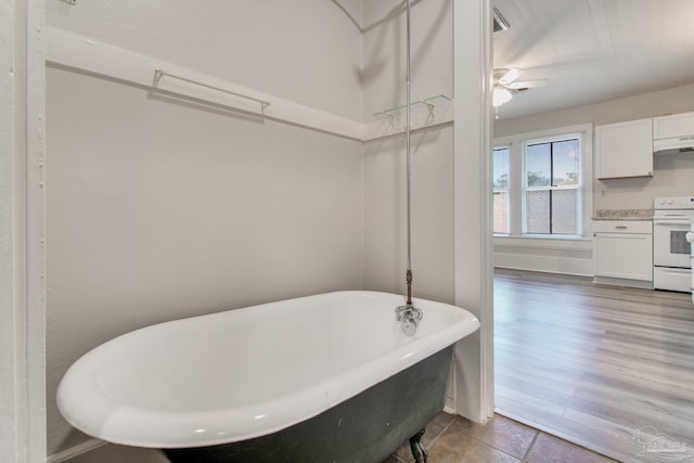 bathroom featuring ceiling fan and a tub