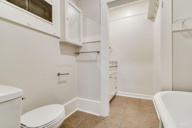 bathroom with a bathtub, vanity, and toilet