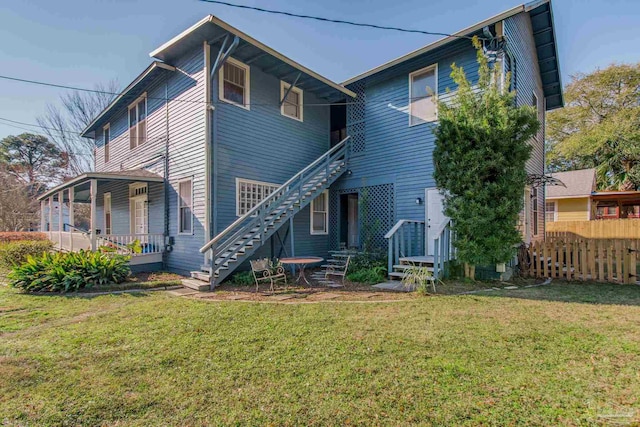 rear view of house featuring a lawn