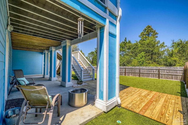 view of patio / terrace featuring fence and stairway