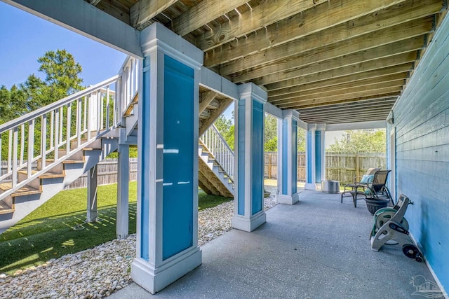 view of patio / terrace featuring stairs and fence