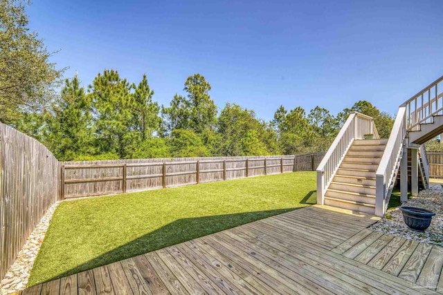 wooden deck featuring stairs, a fenced backyard, and a lawn