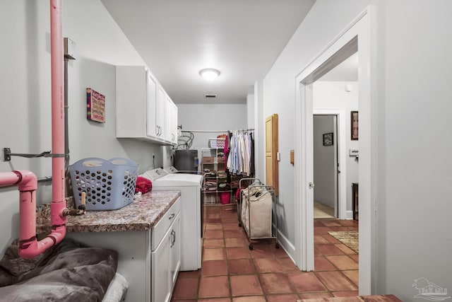 laundry room with tile patterned floors, water heater, independent washer and dryer, and cabinet space