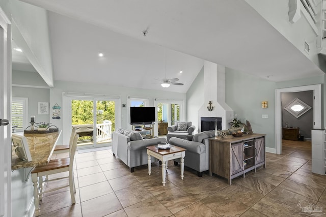 living area with a fireplace, high vaulted ceiling, ceiling fan, and a wealth of natural light