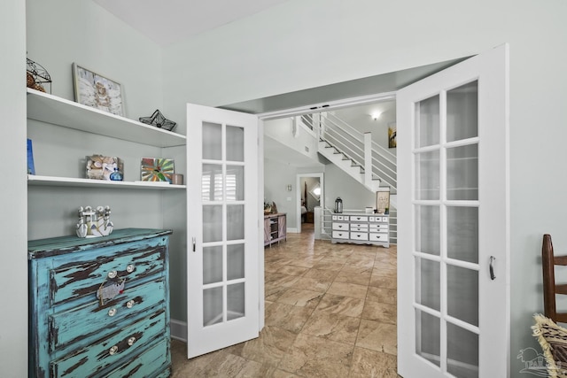 interior space with french doors, stone finish flooring, and stairway