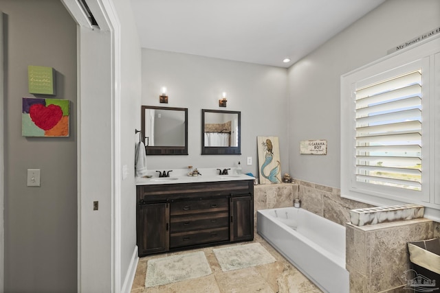 bathroom with double vanity, a bath, stone finish floor, and a sink