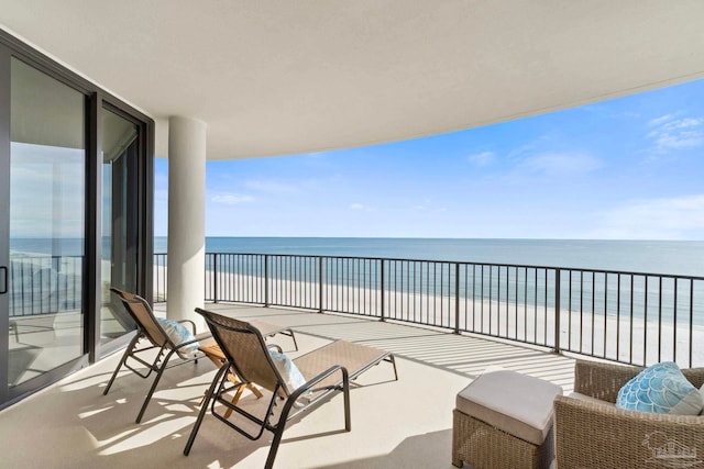 balcony featuring a water view and a beach view