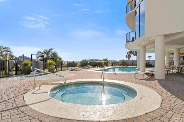 view of swimming pool featuring a hot tub and a patio area