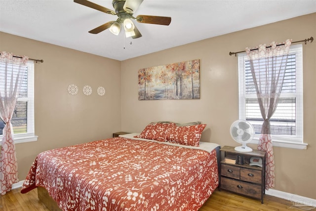 bedroom featuring a ceiling fan, wood finished floors, and baseboards