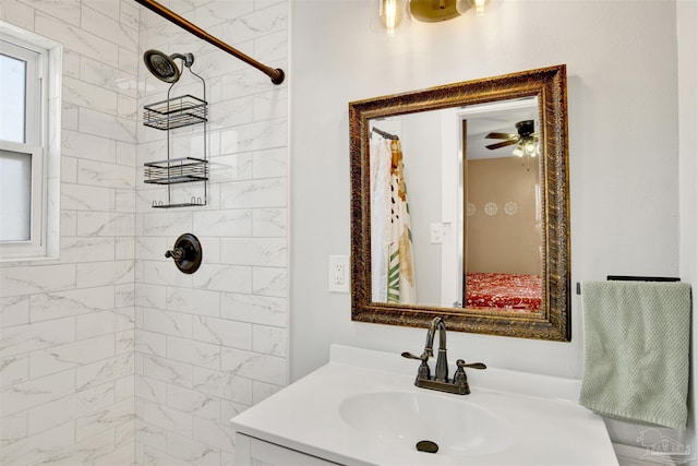 full bath with a tile shower, vanity, and a ceiling fan