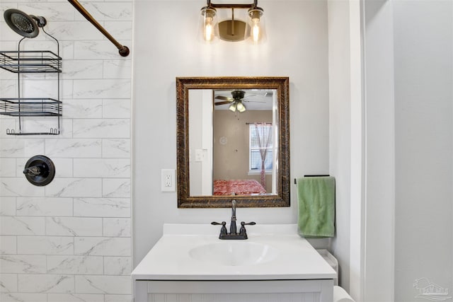 full bath featuring a tile shower, vanity, and ensuite bathroom