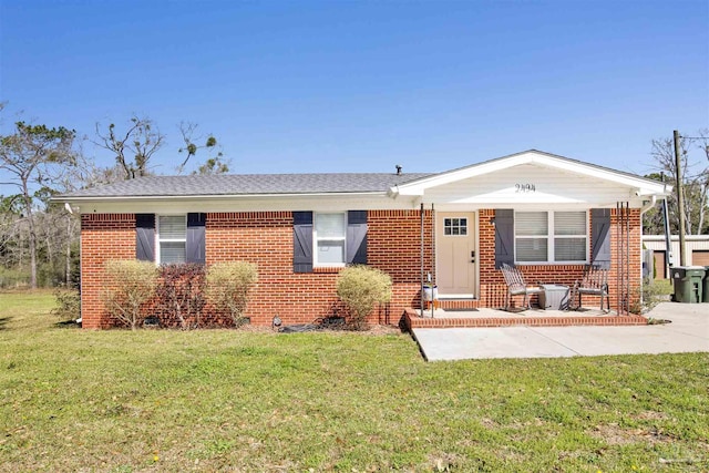 view of front of house with crawl space, brick siding, roof with shingles, and a front lawn