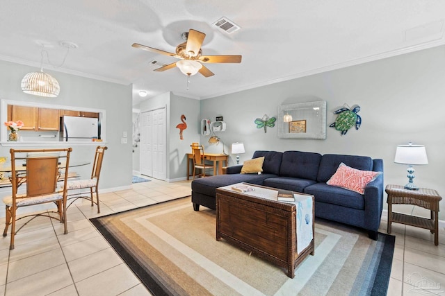 living area with visible vents, ornamental molding, baseboards, ceiling fan, and light tile patterned floors