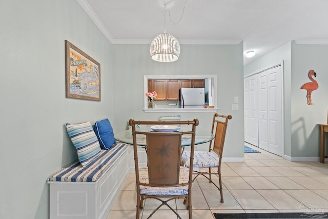 dining area featuring light tile patterned floors, baseboards, and ornamental molding